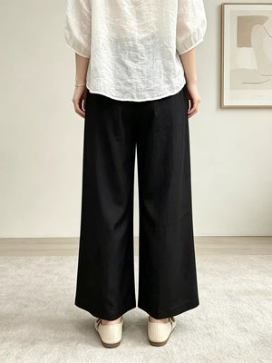 Black maternity pants with pockets and a wide leg, shown from the back.