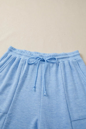 Light blue knit jogger pants with drawstring waist and pockets.
