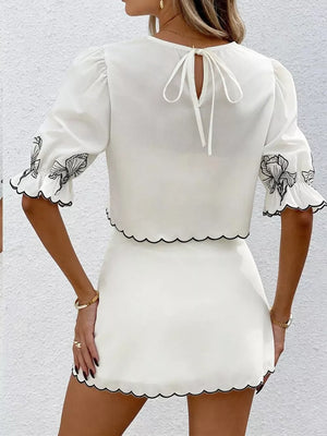 White embroidered floral two-piece set with black scallop trim and tie-back crop top.