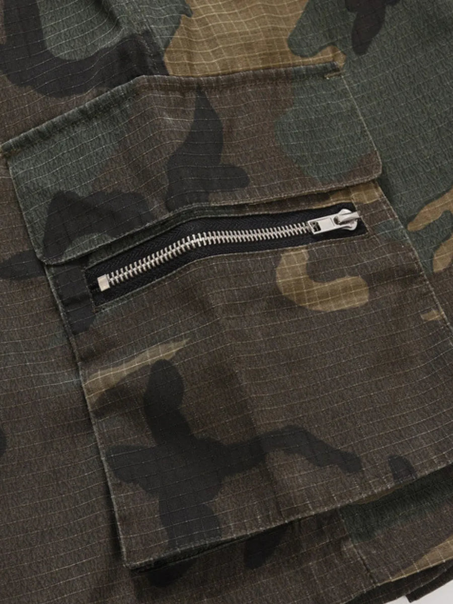 Utility camo cargo shorts in green camouflage with a zippered pocket detail.