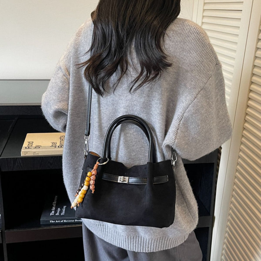 handbag in black featuring top handles and structured fit