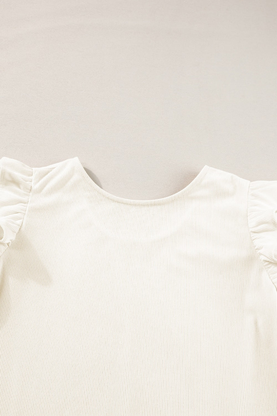 Eggshell textured blouse with ruffle sleeves and a scoop neck.