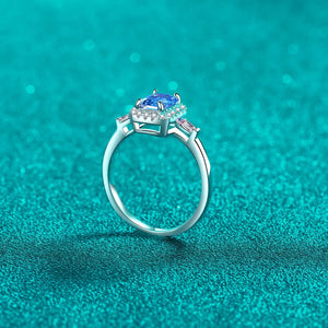 Emerald cut royal blue moissanite halo ring in sterling silver with accent stones.