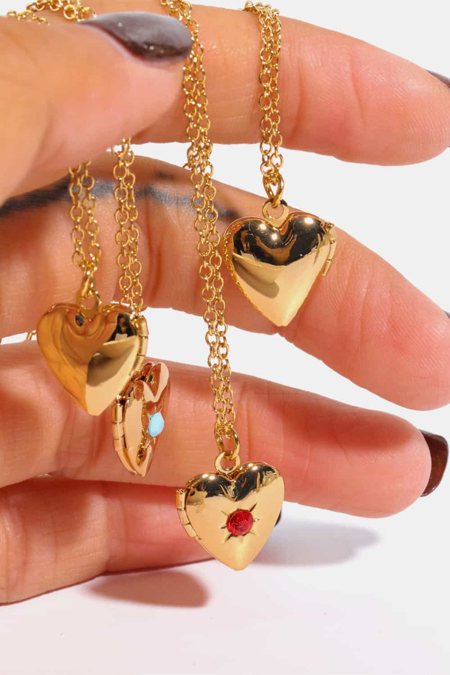 Gold heart locket necklaces with gemstone details, one open with turquoise.