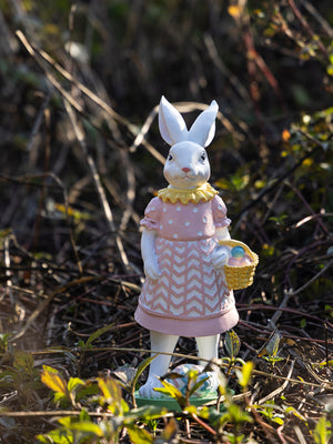 Blush pink Easter bunny ornament in a polka dot dress holding a basket of eggs.