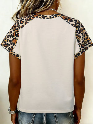 Beige short sleeve blouse with leopard print raglan sleeves and crew neck.