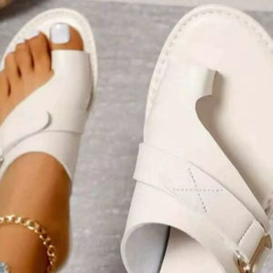 Elegant white toe ring sandals with buckle detail and ankle strap.