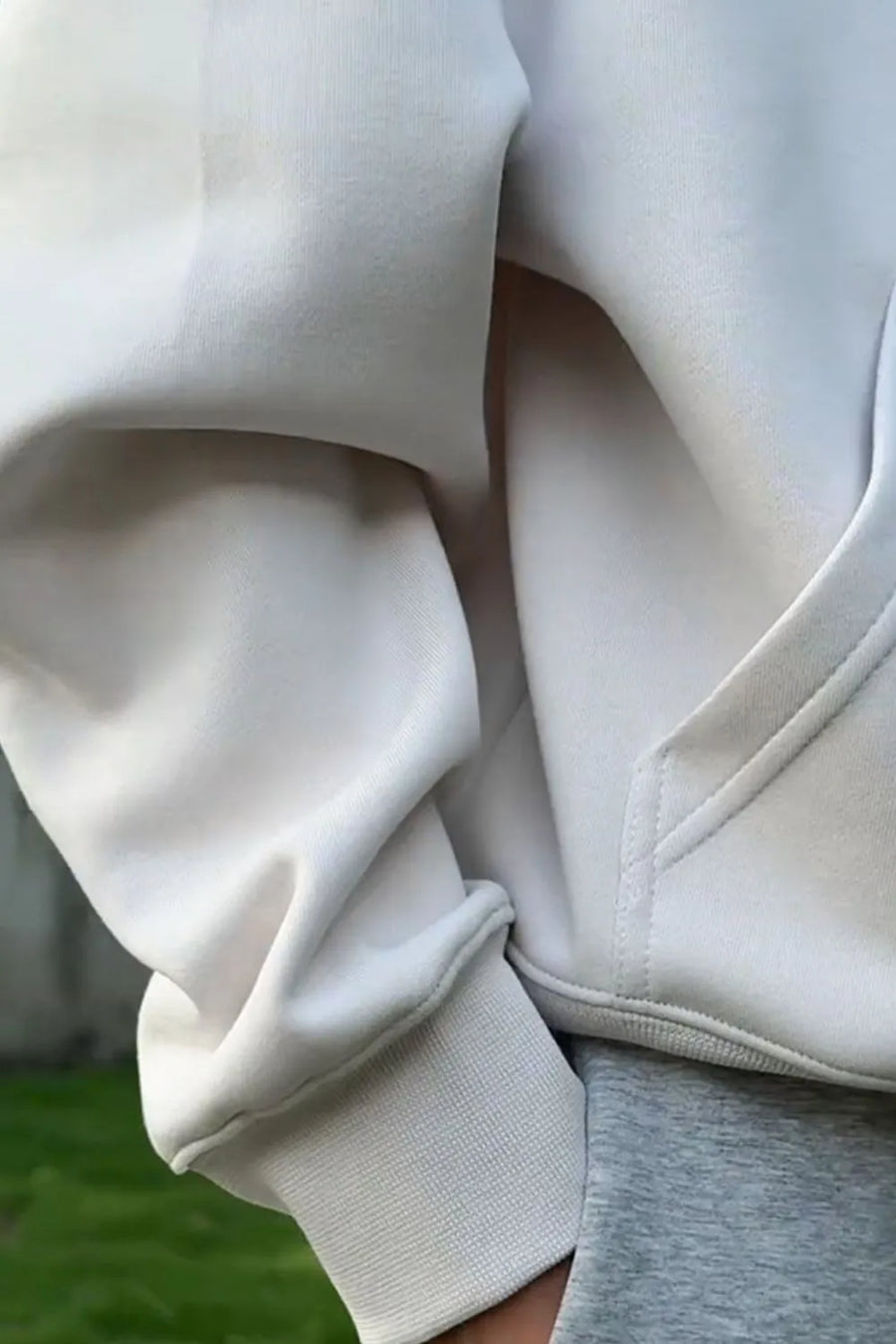 Light gray oversized slouch hoodie with kangaroo pocket and ribbed cuffs.
