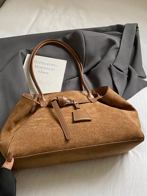 Women's chic brown suede shoulder bag with leather trim and buckle detail.