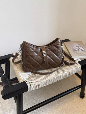 Brown crossbody bag featuring quilted design and quilted