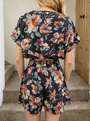 Floral two-piece set in navy blue with a crop top and shorts, featuring short sleeves and elastic waist.