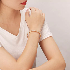 bracelet in gold featuring zircon embellishment and open cuff fit