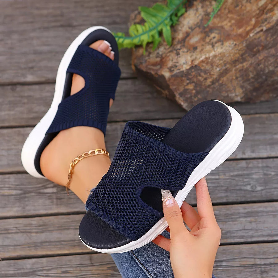 Dark blue mesh slide sandals with open toe and white sole.