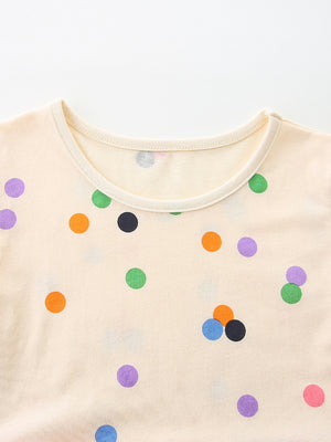 Cream cotton toddler dress with colorful polka dots and a round neckline.