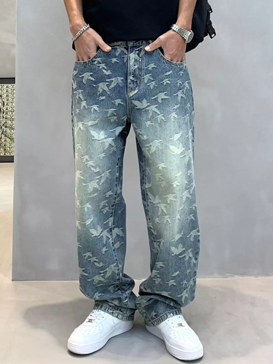 Loose-fit denim jeans with all-over bird print in light wash blue cotton.