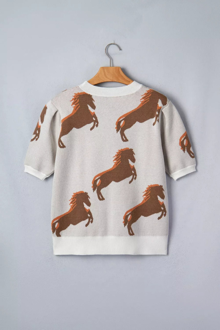 Beige knit sweater with puff sleeves and all-over brown horse print.