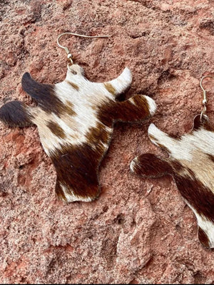 Cowhide silhouette drop earrings in brown with gold hooks.