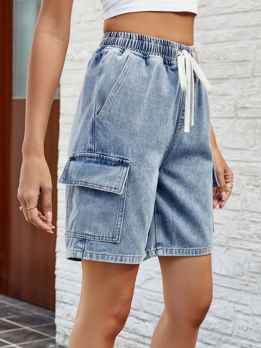 Denim cargo shorts in dusty blue with drawstring waist and utility pockets.