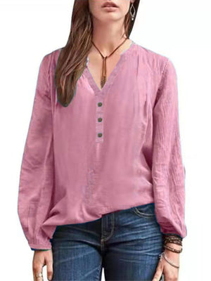 Pink long-sleeve blouse with notched neckline and button detail.