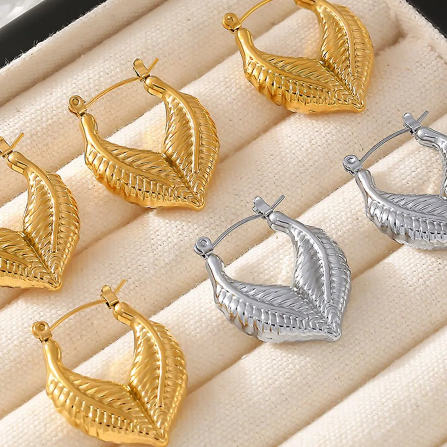 Textured gold leaf hoop earrings in gold and silver finishes.