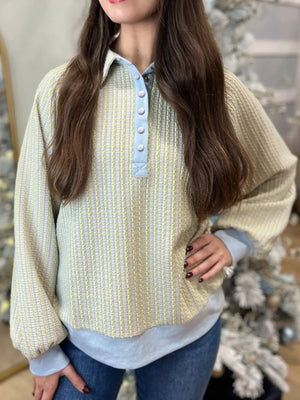 Buttoned half snap sweatshirt in light green with a textured stripe pattern and light blue collar and placket.