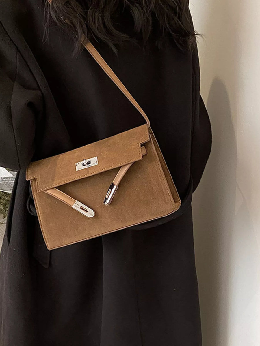 Elegant buckle shoulder bag in coffee color suede with silver hardware.