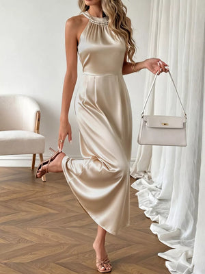 Champagne satin midi dress with pearl neckline, halter style, A-line cut.