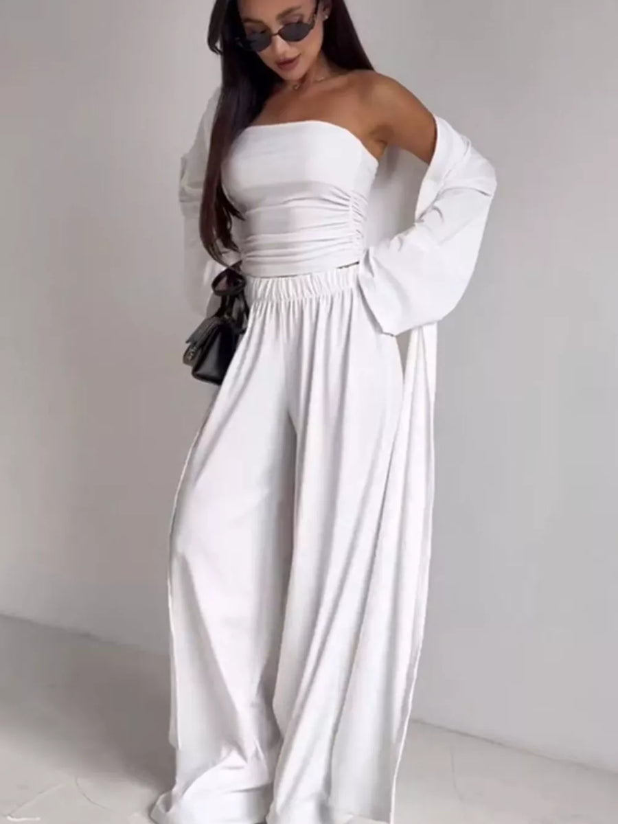White ruched strapless crop top with wide-leg pants and a flowing cardigan.