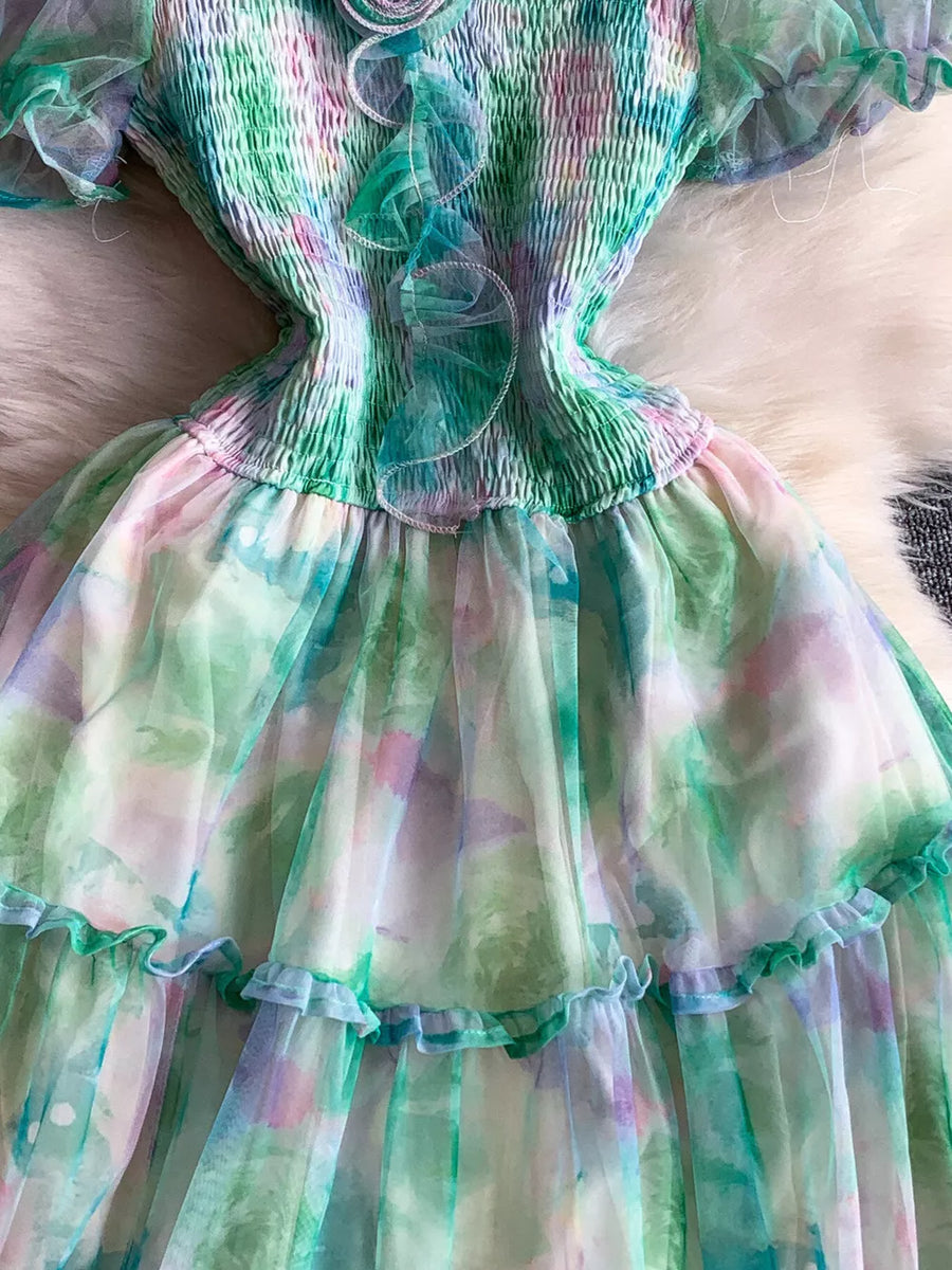 Floral tiered midi dress in light green with smocked bodice and ruffled details.