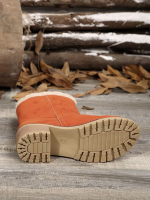 Orange suede ankle boots with sherpa trim and lug sole.