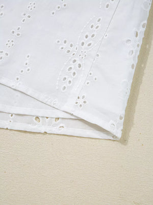 White cotton maternity blouse with delicate eyelet embroidery and ruffled details.