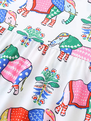 Toddler dress with colorful elephant print and floral accents on white fabric.