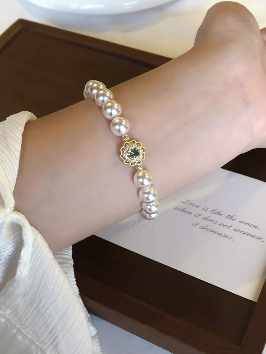 gold bracelet featuring pearl beads and floral