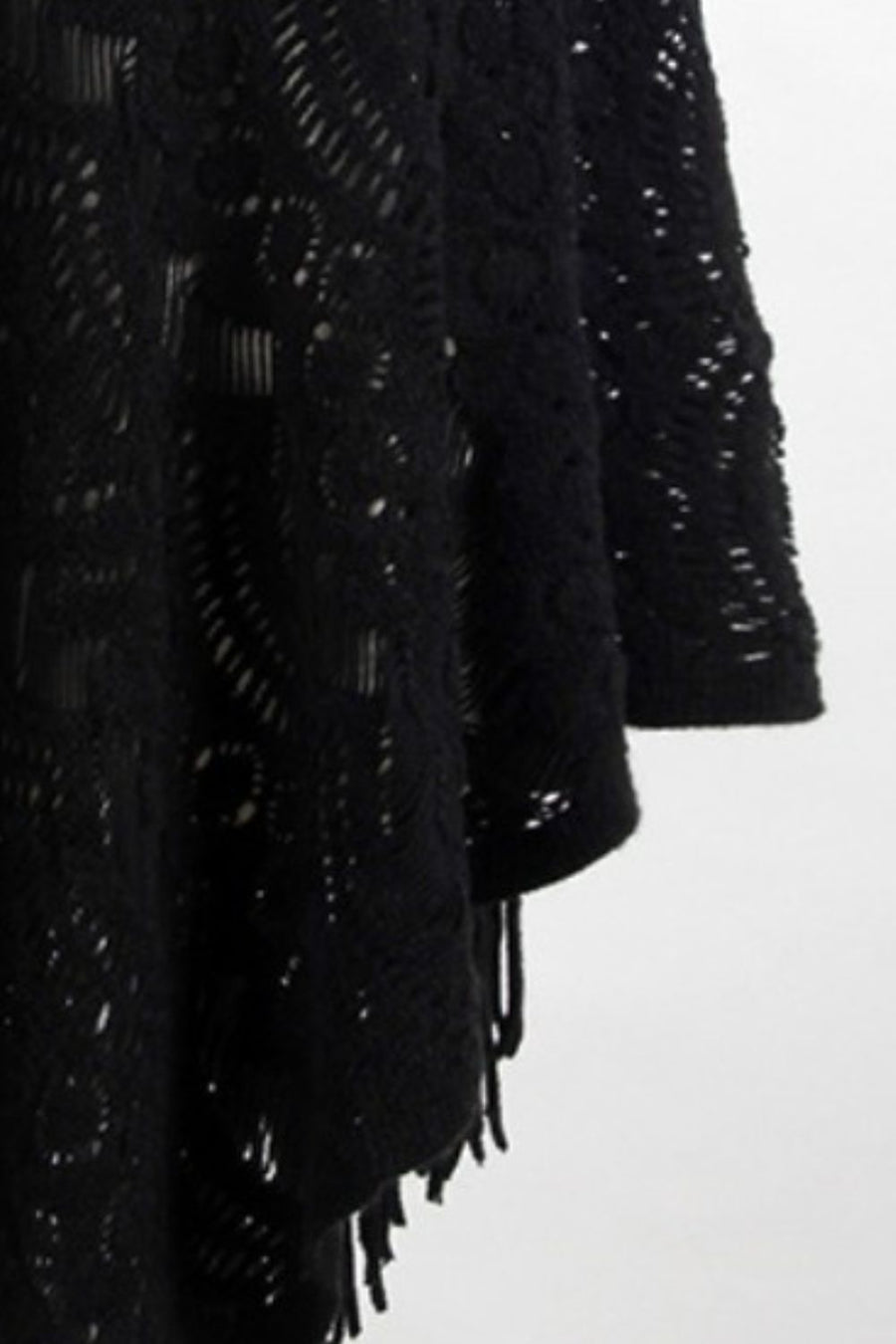 Black crochet poncho with open knit pattern and fringe detail