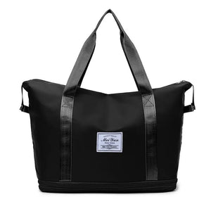 Black expandable travel tote with contrast trim and dual top handles.
