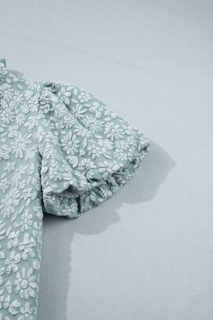 Embroidered puff sleeve floral shirt in light green polyester with textured white floral pattern.