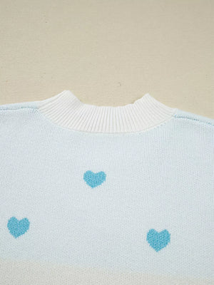 Light blue knit sweater with white crew neck and scattered blue hearts pattern.