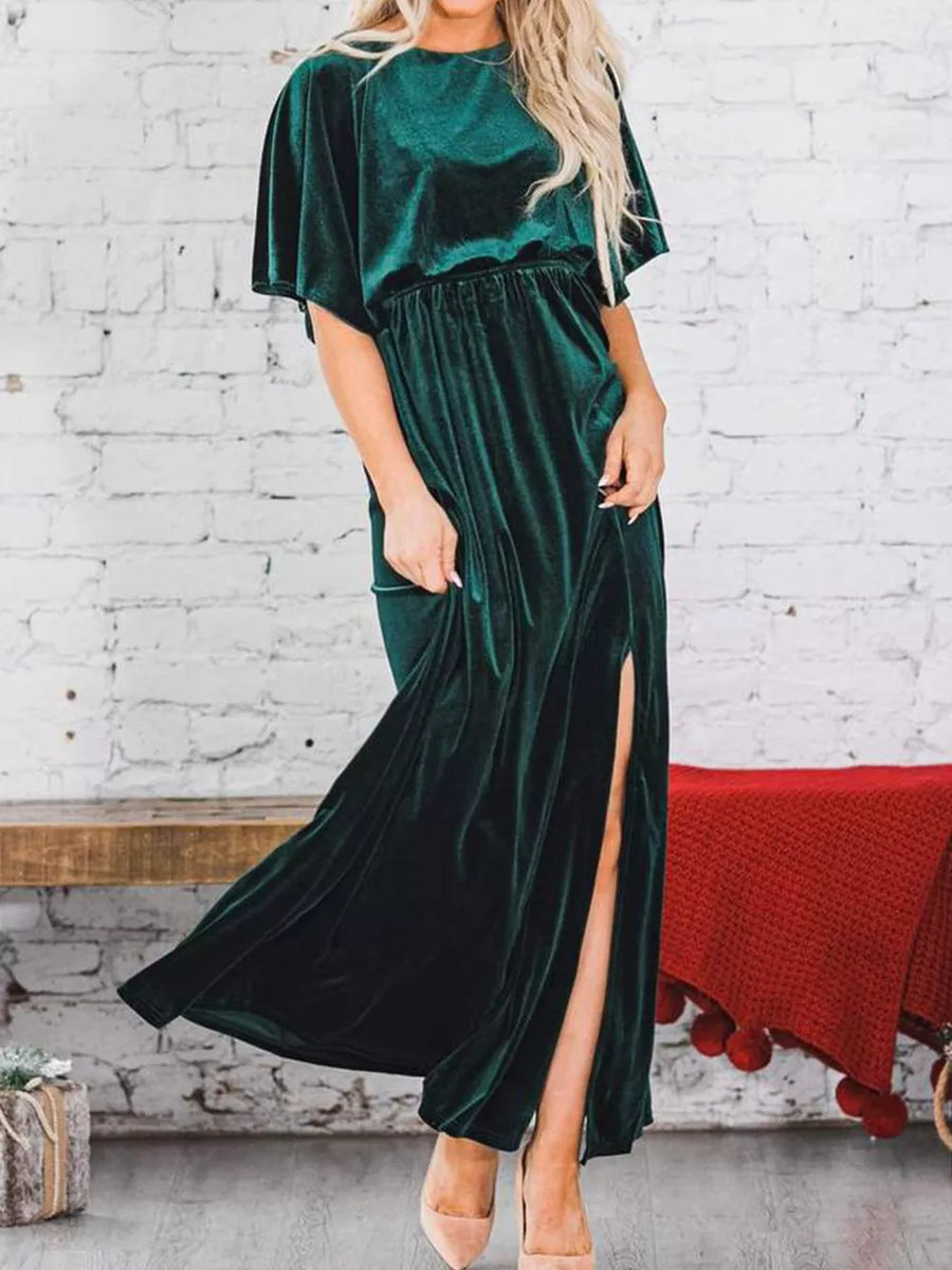 Green velvet maxi dress with flutter sleeves, cinched waist, and high slit.