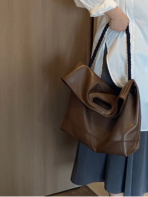 Oversized brown PU leather tote bag with cutout handles and rope straps.