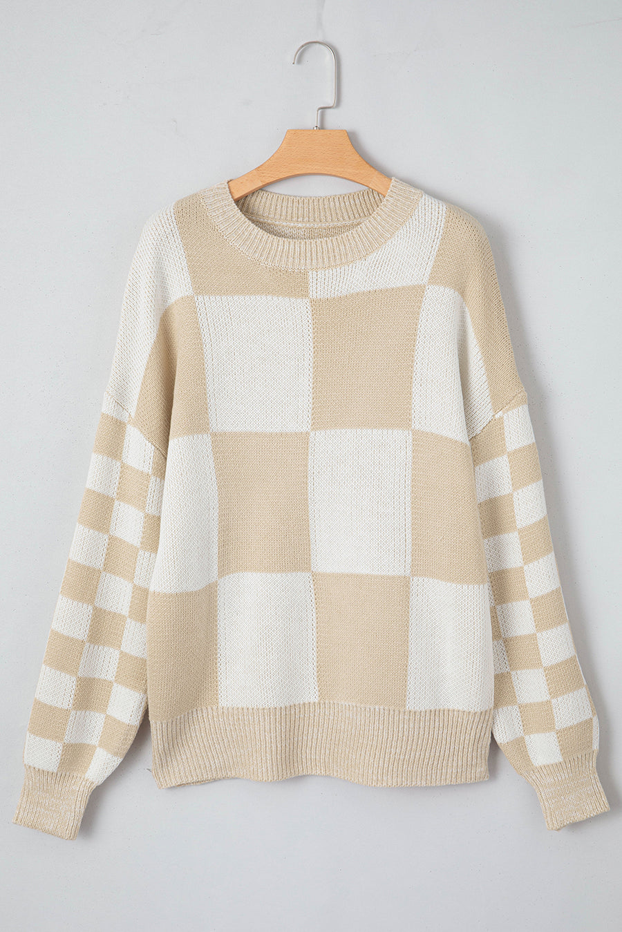 Beige and white checkerboard knit sweater with crewneck and ribbed cuffs and hem.