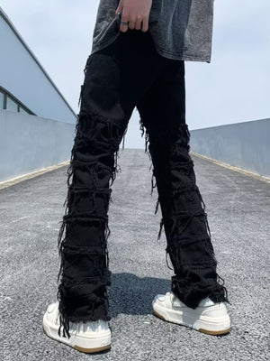 Black distressed slim fit jeans with frayed detailing on the legs.