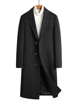 Men's dark gray longline wool buttoned overcoat with classic lapels and a white turtleneck.