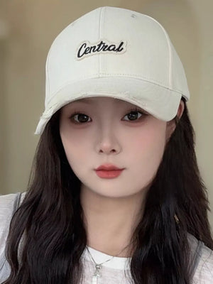 Cream baseball cap with embroidered Central logo and distressed brim.
