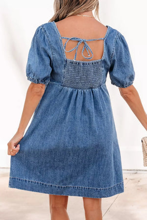 Denim dress with square neck, smocked back, puff sleeves, and tie detail.