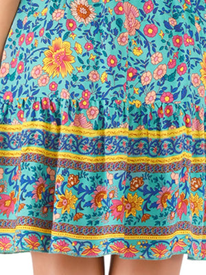 Vibrant floral mini dress with tiered hem and striped border detail.
