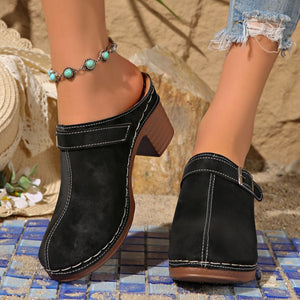 Black round toe platform slip-ons with contrast stitching and block heel.