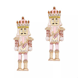 Blush pink nutcracker dangle earrings with pearl accents and gold details.