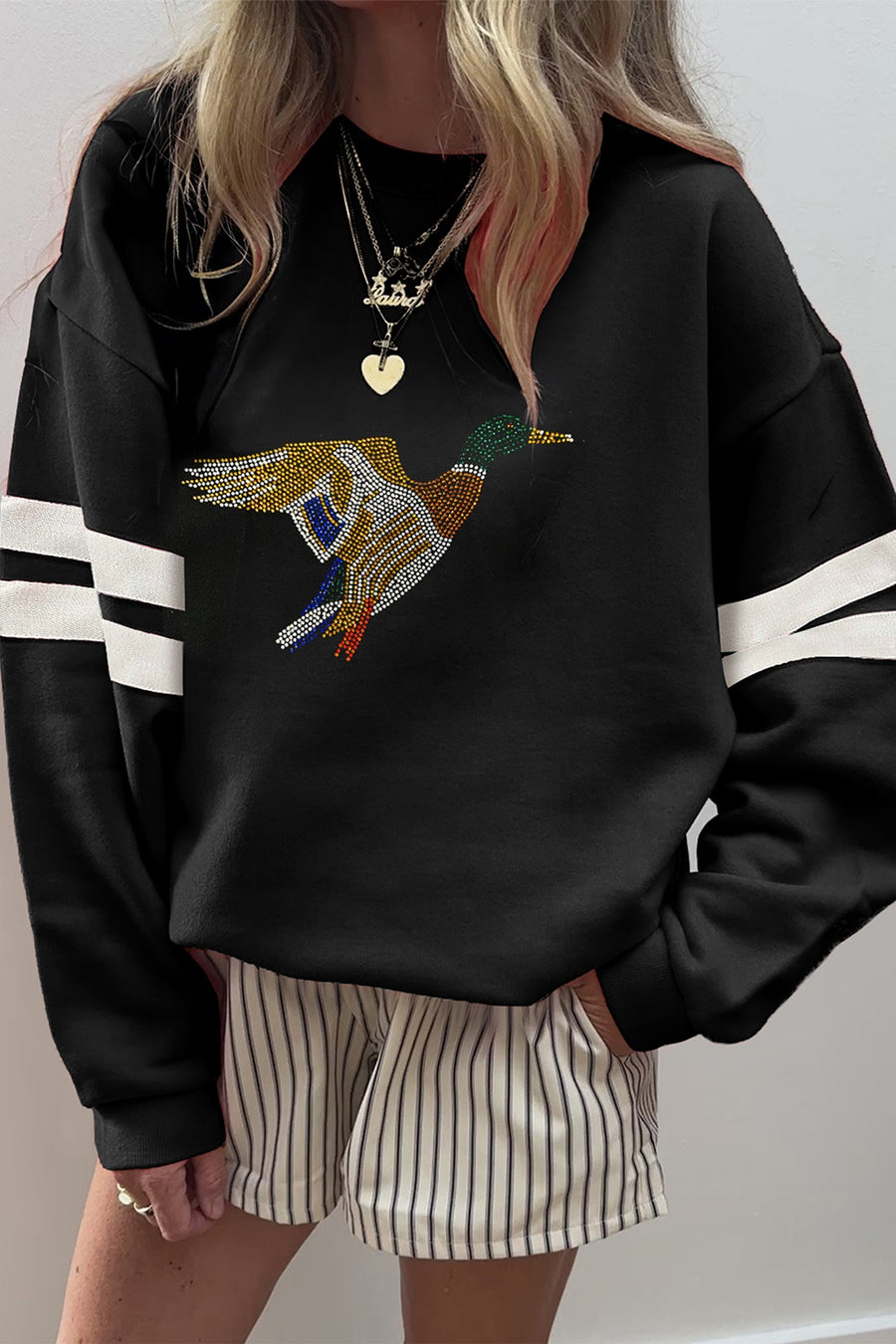Black sweatshirt featuring rhinestone embellishment and graphic-print