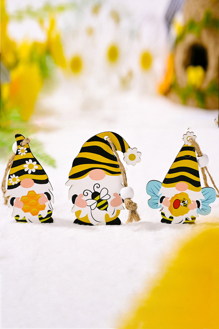 Whimsical bee gnome ornaments in yellow and black with honeycomb, bee, and daisy details.