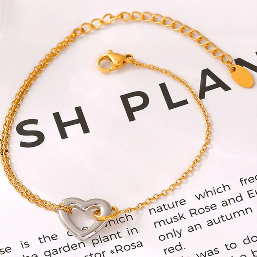 Gold two-tone heart charm bracelet with a delicate chain and lobster clasp.